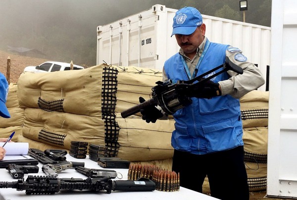 Membro da missão da ONU na Colômbia inspeciona armas entregues pelas Farc. Foto: EFE